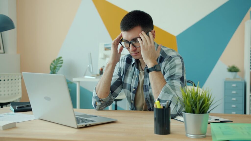 Homem Segurando a Cabeca Em Frustracao Na Mesa Com Laptop xQ93cUceb74