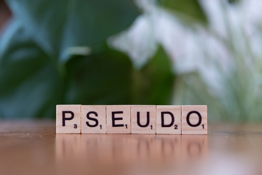 Um Bloco De Scrabble Soletrando a Palavra Ps Seudo Em Uma Mesa yxYGSjw_T0s